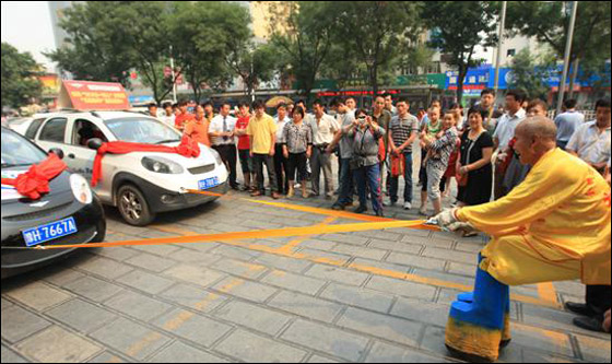 بالصور.. "هرقل" الصيني يجر سيارتين بإصبعين فقط!!