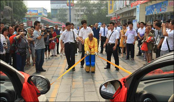 بالصور.. "هرقل" الصيني يجر سيارتين بإصبعين فقط!!