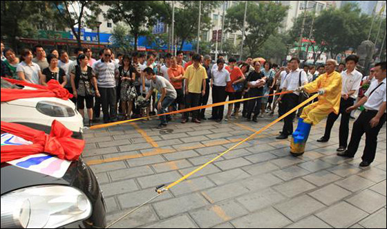 بالصور.. "هرقل" الصيني يجر سيارتين بإصبعين فقط!!