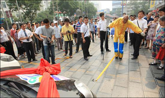 بالصور.. "هرقل" الصيني يجر سيارتين بإصبعين فقط!!