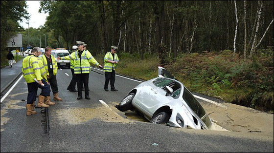 بالصور.. الارض تنشق وتبتلع سيارة بريطاني في وسط الشارع!