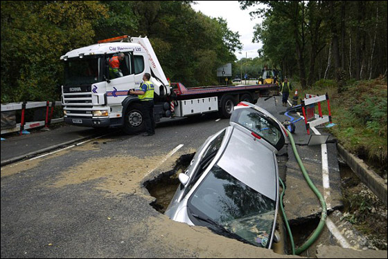 بالصور.. الارض تنشق وتبتلع سيارة بريطاني في وسط الشارع!