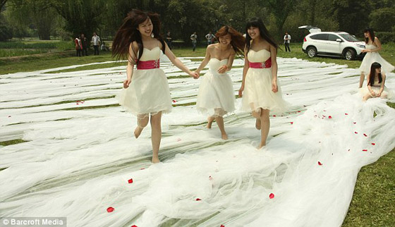 20 فتاة لحمل ثوب عروس طوله 520 مترا ووزنه 50 كيلوجراما